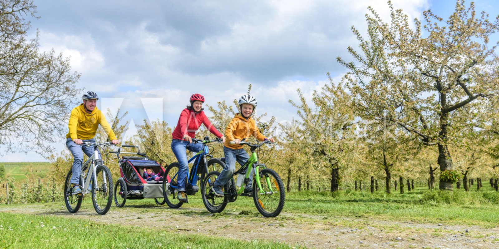 Junge Familie auf e-Bikes bei schönem Wetter